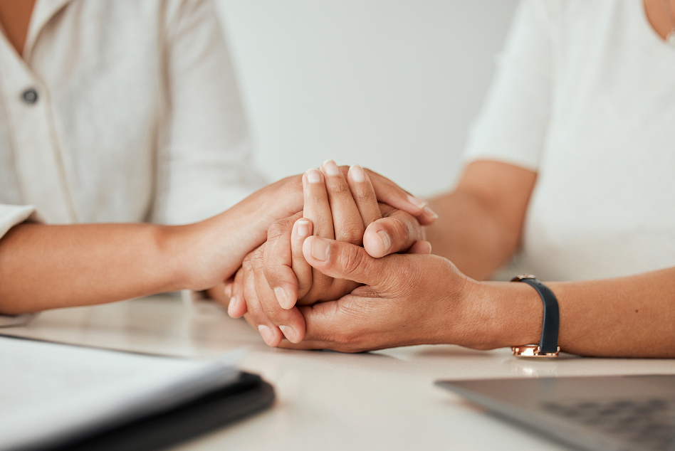 two people holding hands over a table