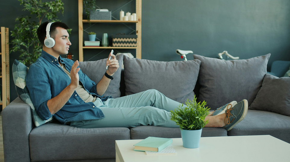 young man wearing headphones and talking to someone over a video call