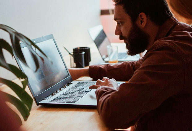 a man surfing the internet on his laptop