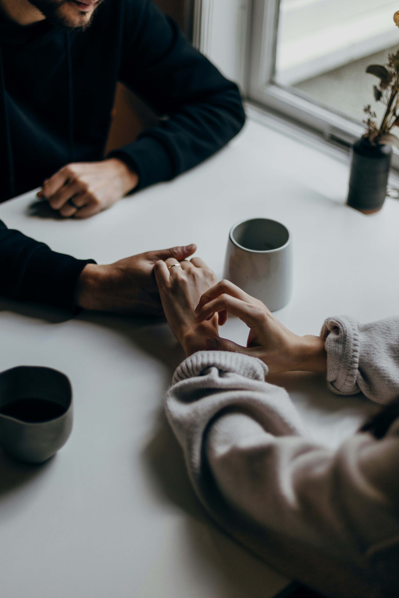a couple holding hands over a cafe table